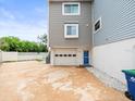Side view of a two-story home featuring a ground-level garage with white door and a charming blue entry door at 619 2Nd St # 3, Indian Rocks Beach, FL 33785