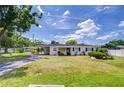 Charming single-story home features a well-manicured lawn and welcoming carport, with traditional shutters at 6612 N Orleans Ave, Tampa, FL 33604