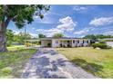 Inviting front exterior features a cozy carport and lush lawn, perfect for enjoying outdoor living at 6612 N Orleans Ave, Tampa, FL 33604