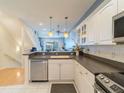 Bright kitchen featuring white cabinets, stainless steel appliances, and modern lighting fixtures at 8304 Aquila St, Port Richey, FL 34668