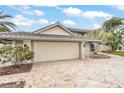 Two story home with tile roof and stone driveway, landscaped yard and two car garage at 892 Harbor Is, Clearwater Beach, FL 33767