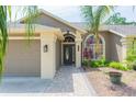 Inviting home featuring a brick walkway, a two-car garage, and beautiful landscaping at 9112 Calle Alta, New Port Richey, FL 34655