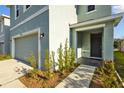Inviting home exterior featuring a two-car garage and landscaped walkway to the front door at 10940 Trailing Vine Dr, Tampa, FL 33610