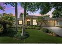 Charming house with lush greenery, mature palms, and a well-manicured lawn with a two-car garage at 1118 Captains Way, Tarpon Springs, FL 34689