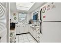 Bright kitchen features white appliances, tile flooring, and a skylight at 11200 102Nd Ave # 48, Seminole, FL 33778