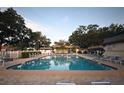 Large community swimming pool with blue water, surrounded by lounge chairs and lush trees at 11485 Oakhurst Rd # 312, Largo, FL 33774