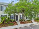 Exterior of gray townhome with black shutters, stone steps, and beautiful landscaping at 11541 Fountainhead Dr, Tampa, FL 33626