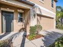 Close up view of home's front door, two car garage, exterior lighting, and landscaping at 15306 Broad Brush Dr, Sun City Center, FL 33573