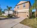 Lovely two-story home with attached two-car garage, beautiful landscaping, and long driveway at 15306 Broad Brush Dr, Sun City Center, FL 33573