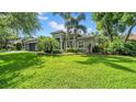 Lush landscaping surrounds a home featuring a gray exterior with a tile roof at 15507 Avocetview Ct, Lithia, FL 33547