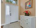 Bright foyer with tiled floor, white wainscoting, and an ornate chest of drawers at 16905 Hawkridge Rd, Lithia, FL 33547