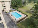 Aerial view of the community pool, with lots of lounge seating and tables, surrounded by mature landscaping at 1817 Golfview Dr # 1817, Tarpon Springs, FL 34689