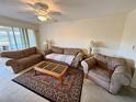 Comfortable living room with plush sofas, a ceiling fan, and a patterned area rug at 225 Country Club Dr # A207, Largo, FL 33771