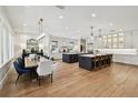 Expansive open-concept kitchen and dining area with hardwood floors and contemporary pendant lighting at 2402 W Parkland Blvd, Tampa, FL 33609