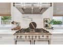 Close-up of the kitchen features a professional-grade gas range, subway tile backsplash, and custom range hood at 2402 W Parkland Blvd, Tampa, FL 33609