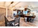 Modern kitchen and dining area with dark cabinetry, stainless steel appliances, and a stylish breakfast bar at 2460 Beacon Groves Blvd, Palm Harbor, FL 34683