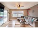 Cozy living room with a large sectional sofa, sliding glass doors, a ceiling fan, and wood-style flooring at 2460 Beacon Groves Blvd, Palm Harbor, FL 34683