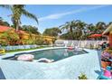 Private backyard pool surrounded by lush greenery and a relaxing patio area at 3122 Lake Valencia E Ln, Palm Harbor, FL 34684
