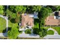 Aerial view of a home featuring a well-manicured lawn, mature trees, and a spacious driveway with ample parking at 3410 Moran Rd, Tampa, FL 33618