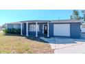 Charming single-story home with blue siding, front porch, and an attached one car garage at 3445 Briar Cliff Dr, Holiday, FL 34691