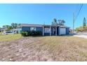 Charming single-story home with blue siding, front porch, and an attached one car garage at 3445 Briar Cliff Dr, Holiday, FL 34691