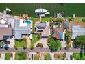 Aerial view of waterfront property featuring pool, boat dock, and solar panels at 3497 Coquina Key Se Dr, St Petersburg, FL 33705