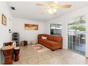 Cozy bonus room with tile flooring, a ceiling fan, orange sofa, and view to the patio at 408 Pineapple St, Tarpon Springs, FL 34689