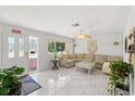 Inviting living room with neutral tones, tile flooring, large window, and comfortable sectional sofa at 408 Pineapple St, Tarpon Springs, FL 34689