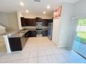 Open kitchen with dark cabinetry, stainless steel appliances, and a breakfast bar at 4461 Globe Thistle Dr, Tampa, FL 33619