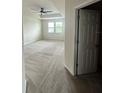 Spacious bedroom with carpet, a ceiling fan, and natural light from large windows at 4697 Wandering Way, Wesley Chapel, FL 33544