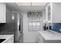 Bright kitchen featuring updated white cabinets, marble countertops, and stainless steel appliances at 601 N Hercules Ave # 1602, Clearwater, FL 33765