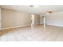A spacious living room with tiled flooring that connects to multiple rooms at 608 Lemonwood Dr, Oldsmar, FL 34677