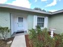 Close-up of the front door with white trim and a storm door, framed by manicured bushes and a bird bath at 612 Bryan Terrace Dr, Brandon, FL 33511
