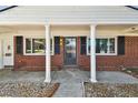 Inviting front porch with classic columns, brick accents, and a storm door entrance at 6922 Spencer Cir, Tampa, FL 33610