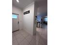 Inviting foyer with tile flooring, leading to an open-concept living space at 6942 Ripple Pond Loop, Zephyrhills, FL 33541
