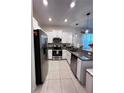 Modern kitchen with stainless steel appliances, granite countertops, and ample cabinet space at 6942 Ripple Pond Loop, Zephyrhills, FL 33541