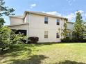 View of the back of the home featuring a manicured lawn and partial fencing for privacy at 7704 Tuscany Woods Dr, Tampa, FL 33647