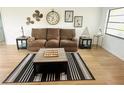Cozy living room features a comfortable couch, wood-look floors, and coastal-themed decor at 8050 Roxburgh Ct, Weeki Wachee, FL 34613