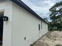 Side view of a white home exterior with a dark roof and manicured lawn at 8149 Cashew, Webster, FL 33597