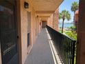 Hallway view with black railing, waterfront view, and sunny skies at 8931 Blind Pass Rd # 257, St Pete Beach, FL 33706