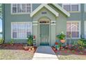 Home featuring a welcoming front door with colorful potted plants and neutral accents at 9304 Lake Chase Island Way, Tampa, FL 33626