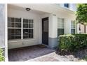 Inviting entrance with a brick-paved patio, featuring a modern door, window, and manicured landscaping at 9628 Charlesberg Dr, Tampa, FL 33635