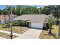 Lovely single-story home with mature palm trees, brick accents, and a spacious driveway at 9730 Reynosa Dr, New Port Richey, FL 34655