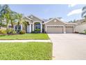 Charming one-story home with a well-manicured lawn, lush landscaping, and a spacious two-car garage at 10016 Oxford Chapel Dr, Tampa, FL 33647