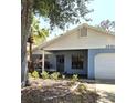 Inviting single-story home featuring a covered entry, attached garage, and manicured lawn at 10918 Freemont Dr, New Port Richey, FL 34654