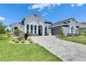 Beautiful curb appeal featuring manicured lawn, paved driveway, and lush, mature landscaping at 13539 Carryback Dr, Dade City, FL 33525