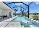 Inviting screened-in pool with attached spa and spacious patio area for lounging at 13539 Carryback Dr, Dade City, FL 33525