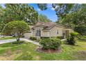 Spacious home with verdant lawn, manicured landscaping, and car in the driveway at 15314 Sherwood Forest Dr, Tampa, FL 33647