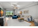 Bright living room featuring hardwood floors, contemporary furniture, and sliding glass doors at 15417 Martinmeadow Dr, Lithia, FL 33547