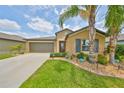 Charming single-story home features a lush green lawn and a welcoming entrance with professional landscaping at 15426 Wicked Strong St, Sun City Center, FL 33573